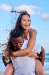Happy young beautiful couple having fun on the beach